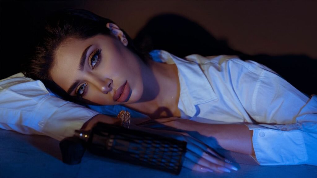 Elegant portrait of a woman in white blouse with captivating makeup and accessories.